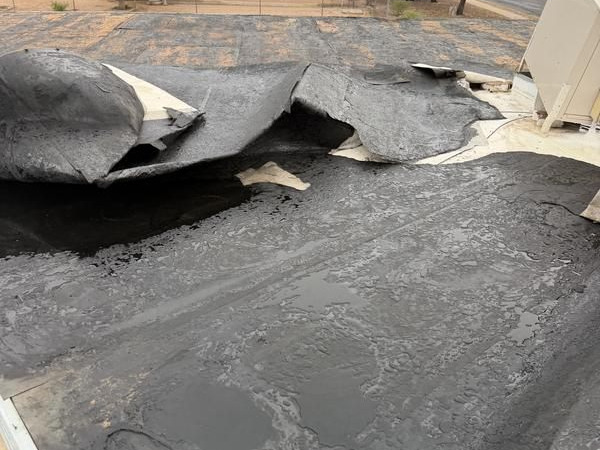 Torn membrane on a commercial flat roof in Tucson before repair