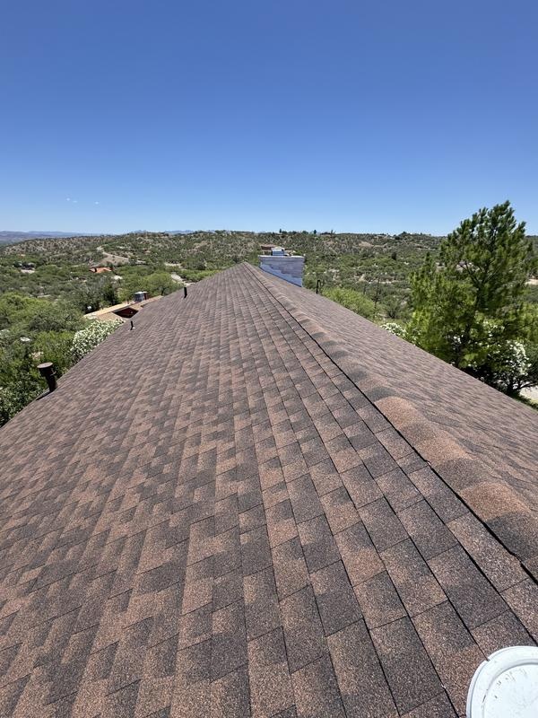 Asphalt shingle roof ridge with a ridge vent overlooking Tucson hills